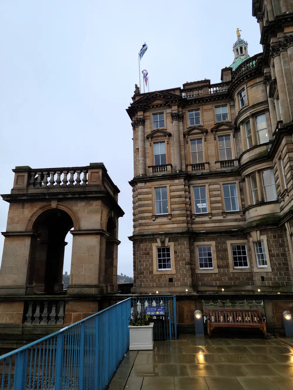Bank of Scotland headquarters dome and sandstone arch viewed from The Mound terrace in Edinburgh with Scottish flags flying