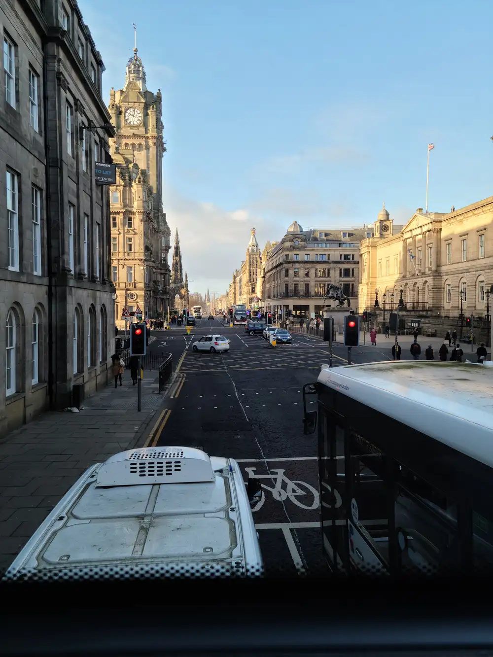 View down Princes Street in Edinburgh from the top deck of a bus, with the Balmoral Hotel clock tower and Register House