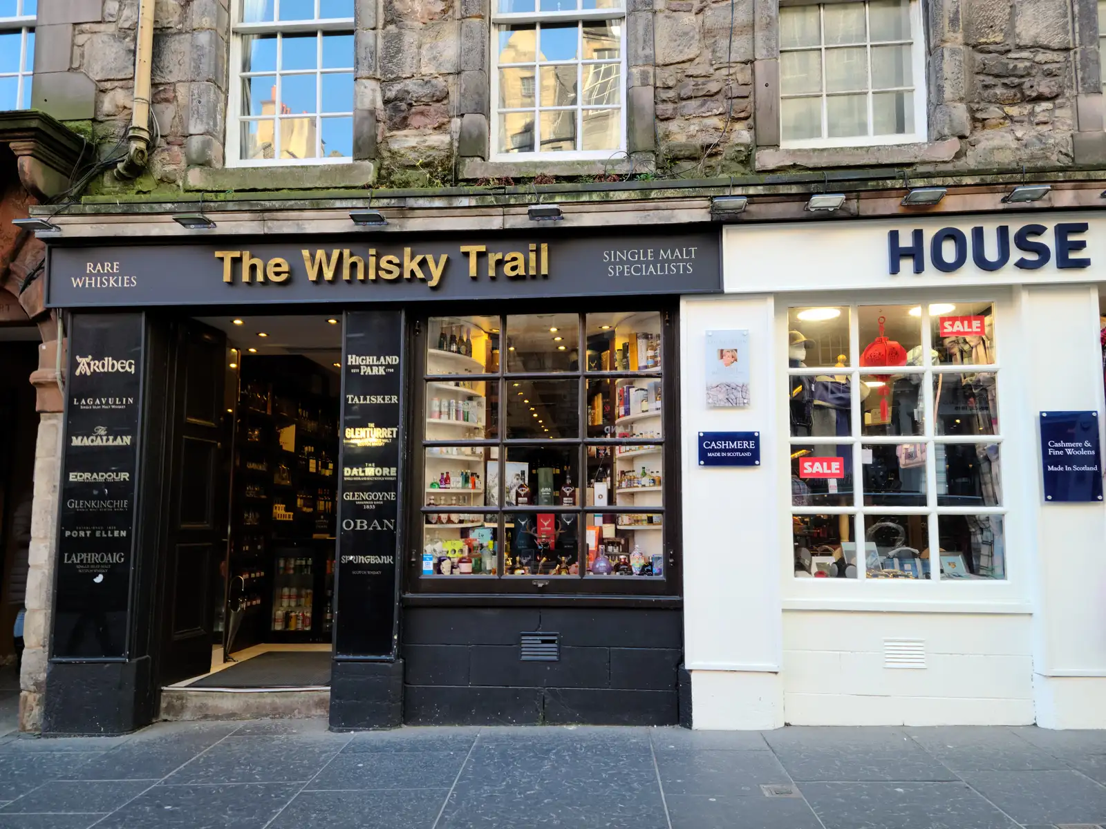 The Whisky Trail single malt specialist shop front on Edinburgh's Royal Mile with rare whisky brands listed beside the door