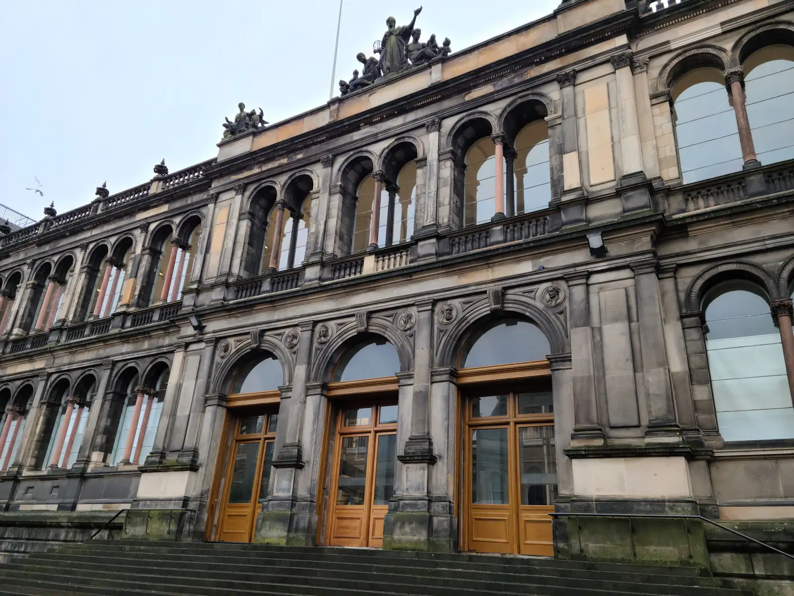 Ornate Victorian sandstone facade of the National Museum of Scotland on Chambers Street with rooftop statues and arched windows