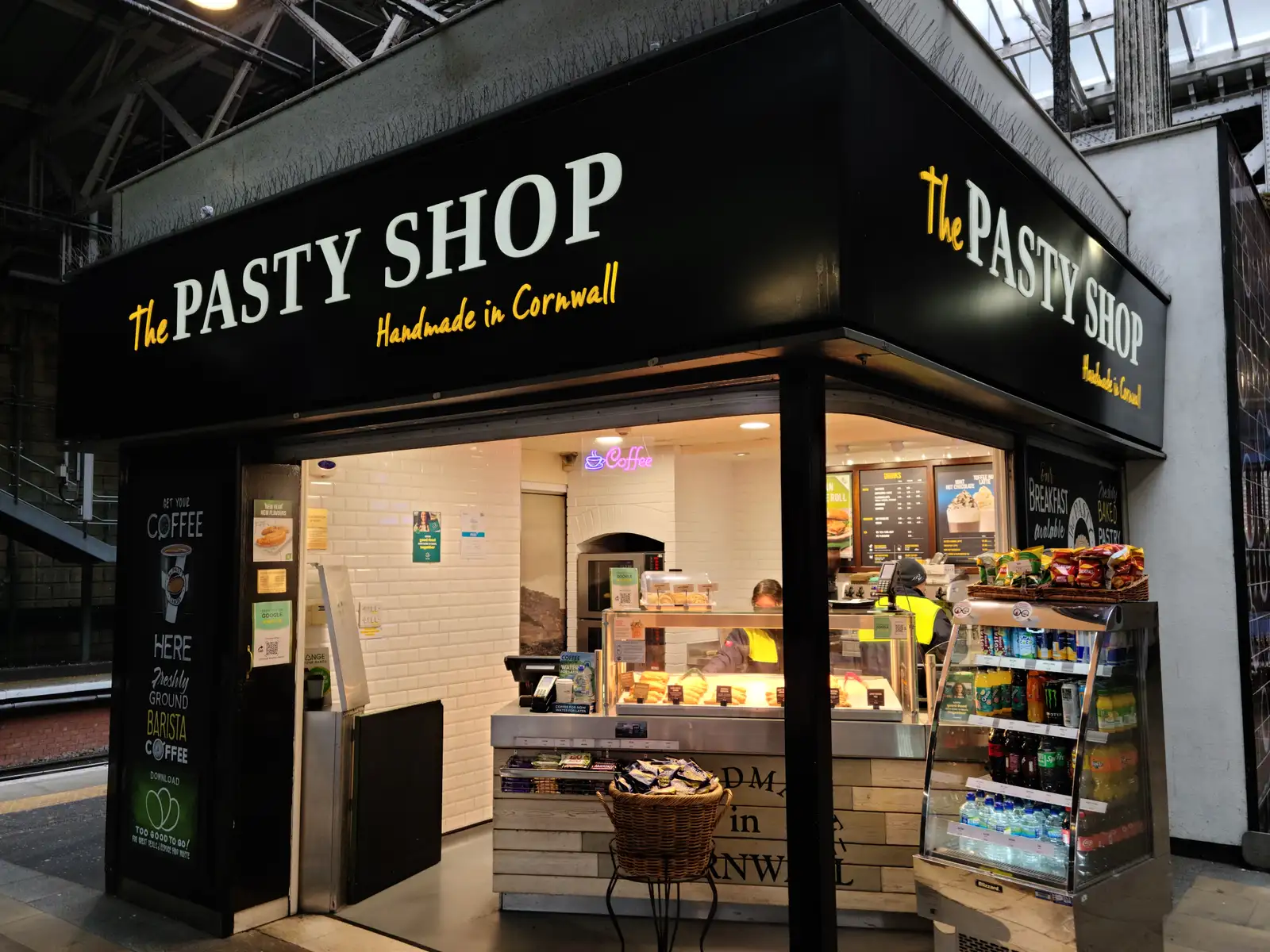 The Pasty Shop kiosk at Edinburgh Waverley Station with handmade in Cornwall signage, pastry counter and coffee fridge
