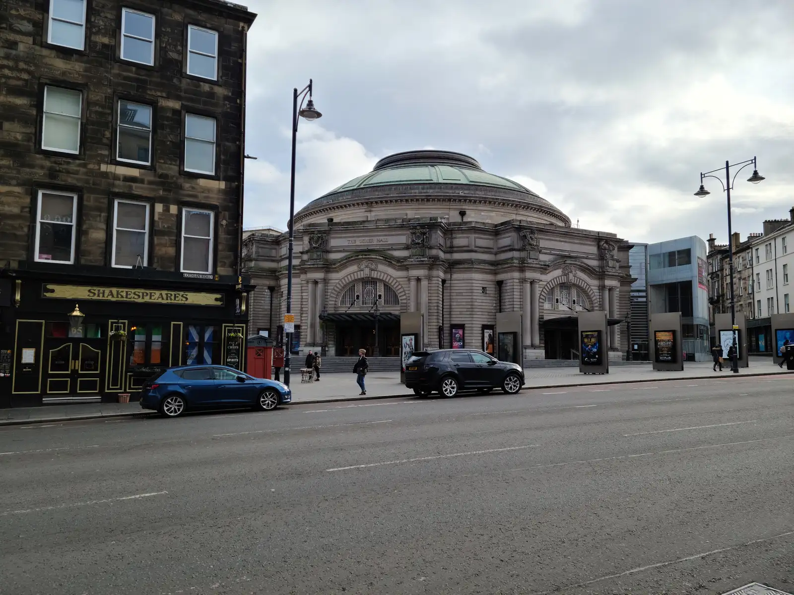 Domed sandstone facade of the Usher Hall concert venue on Lothian Road in Edinburgh with Shakespeare's pub on the left
