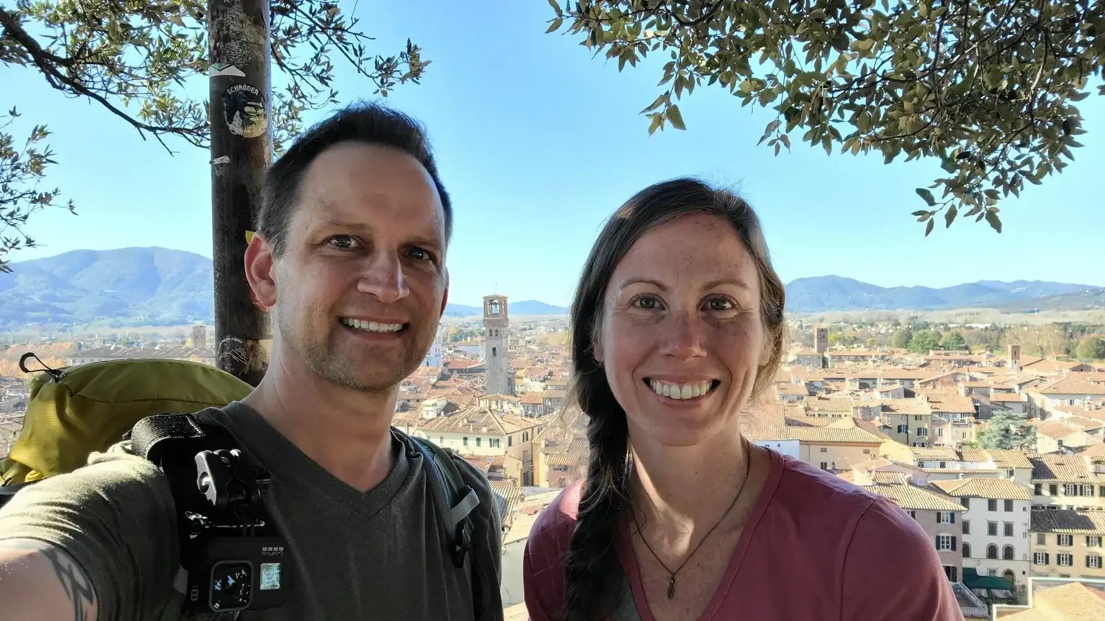 Andrew and Ashley taking a selfie at the rooftop of Torre Guinigi in Lucca with the oak trees and rooftop panorama behind them