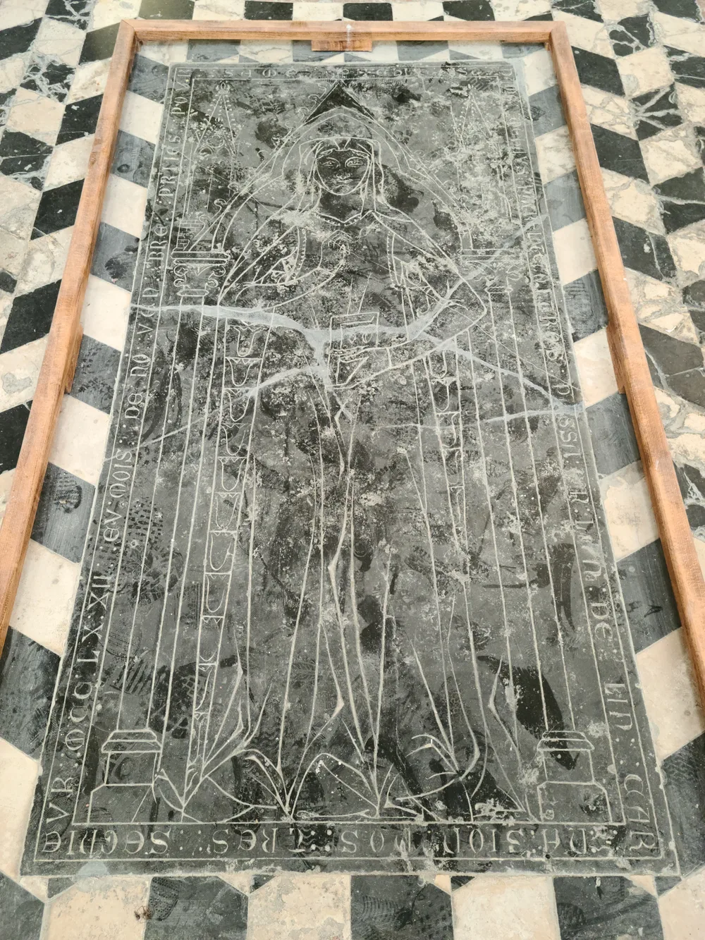 Medieval funerary slab with carved relief figures inside the Basilique de Saint-Quentin