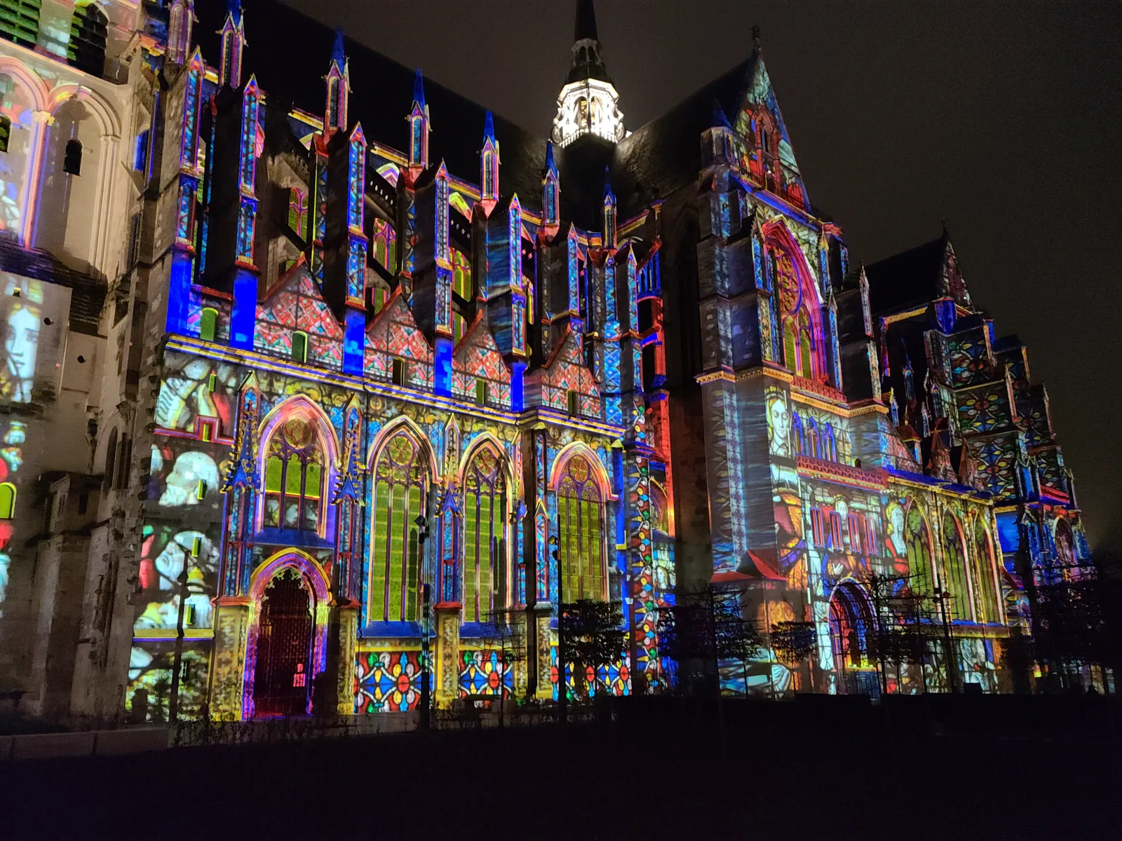Stained glass patterns projected onto the exterior of Basilique de Saint-Quentin during an evening light show