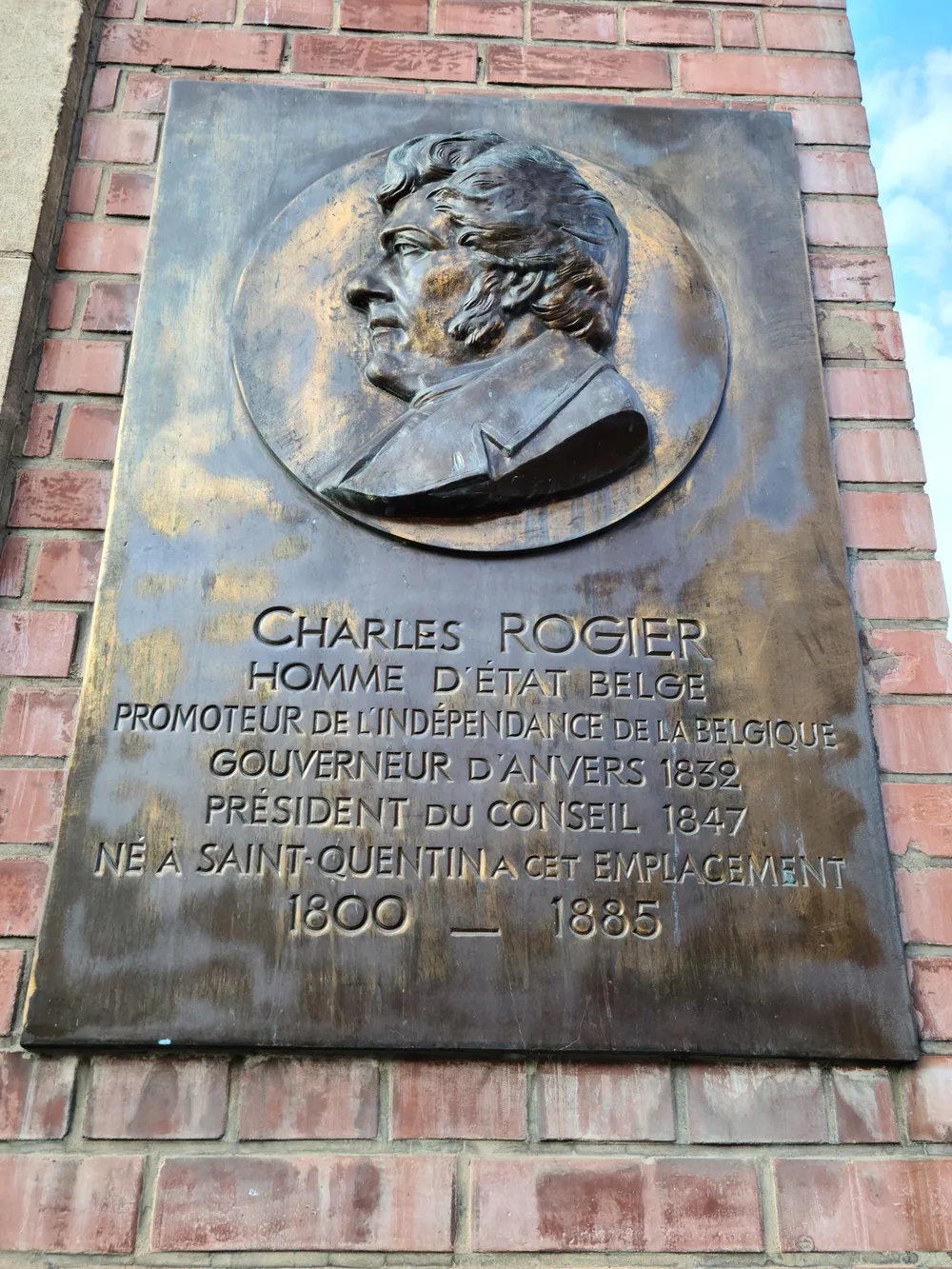 Bronze memorial plaque to Charles Rogier mounted on a stone building in Saint-Quentin