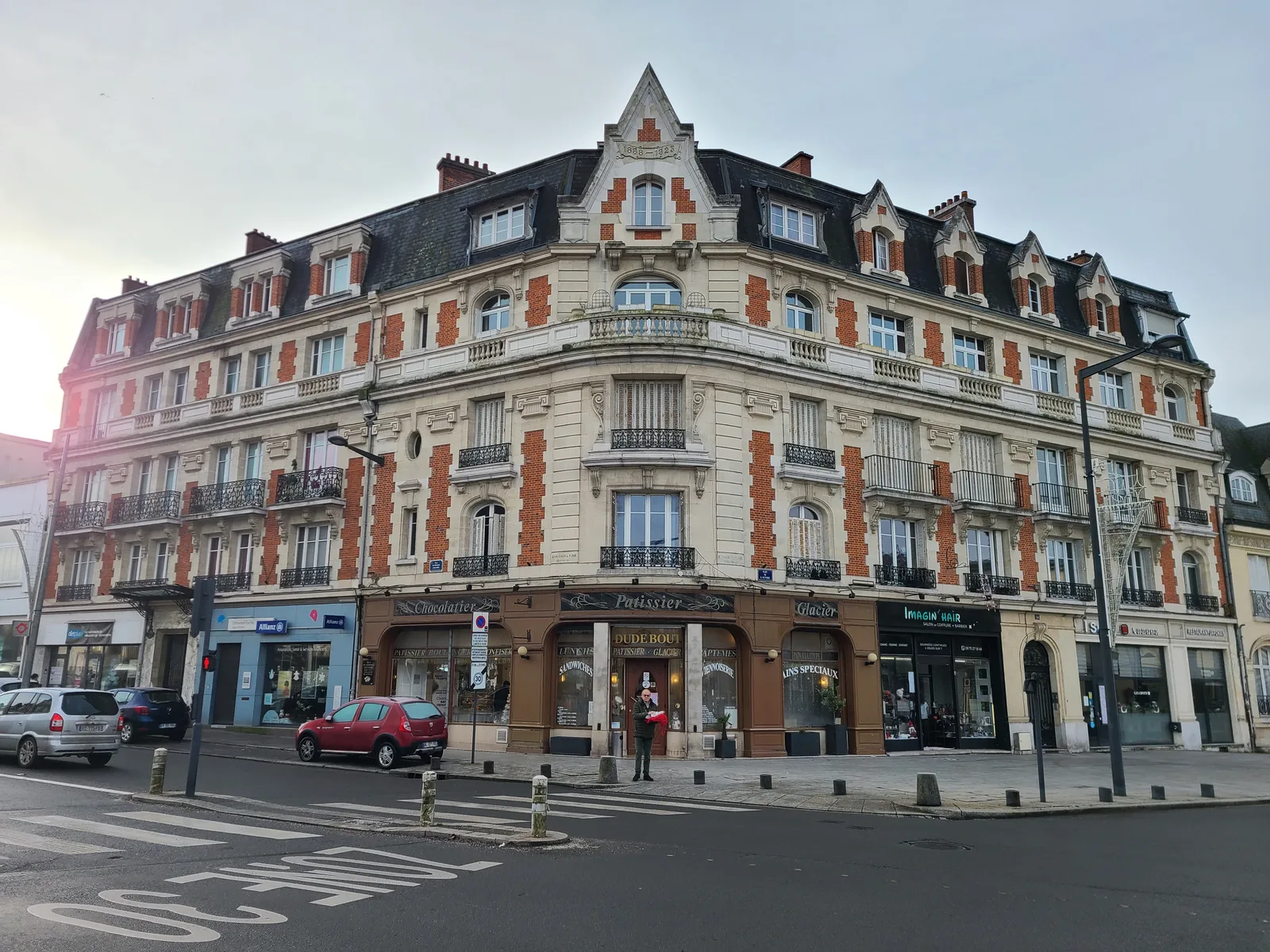 Haussmann-style corner building with ground-floor shops on a Saint-Quentin street