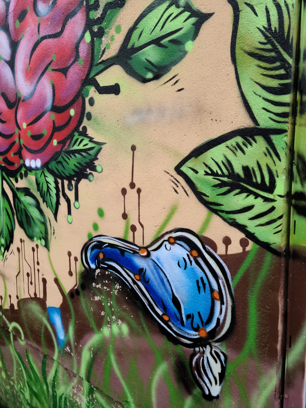 Street art mural of Salvador Dali's melting clock on a building wall in Saint-Quentin