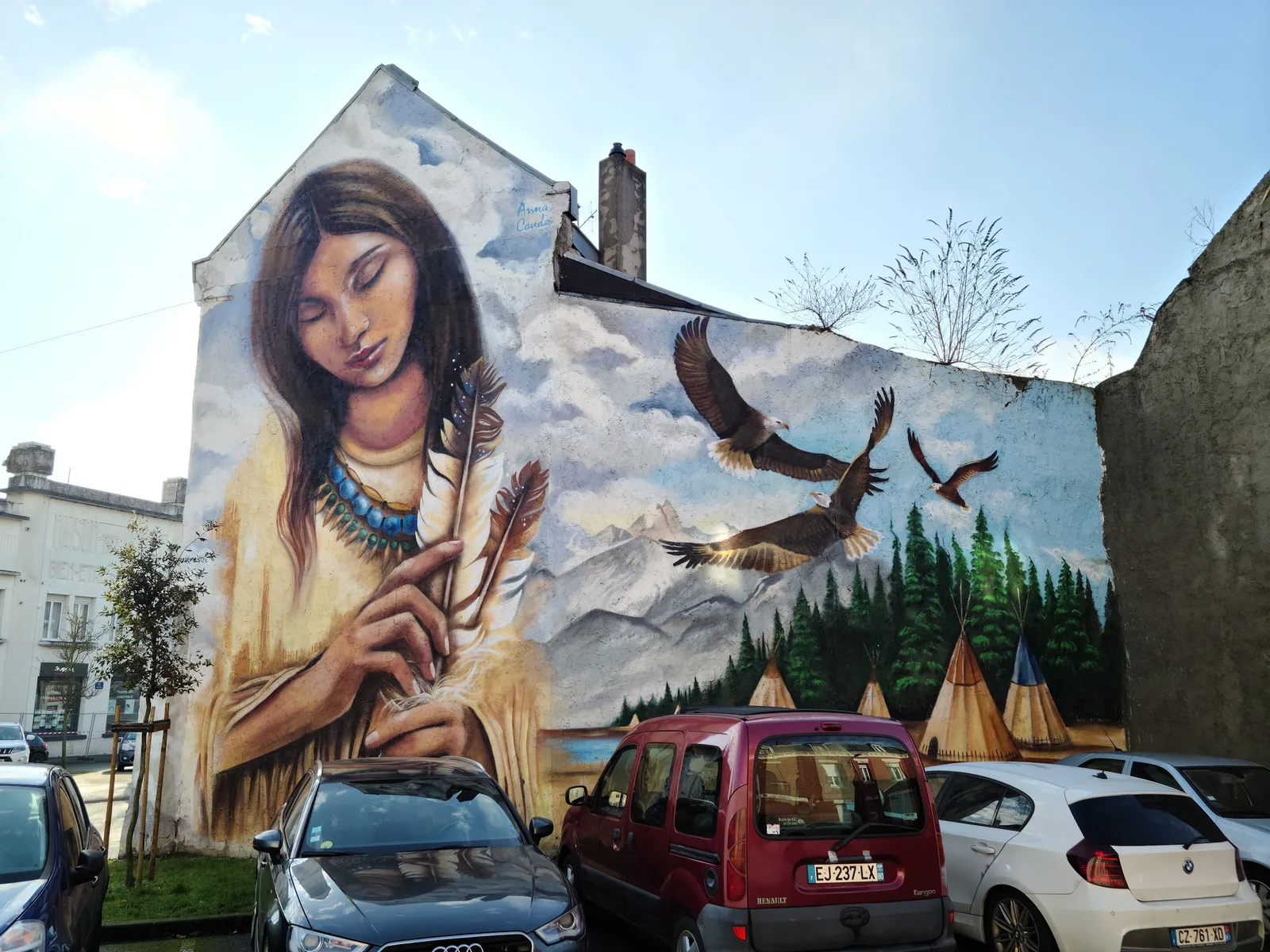 Street art mural featuring a Native American figure and eagles on a building in Saint-Quentin